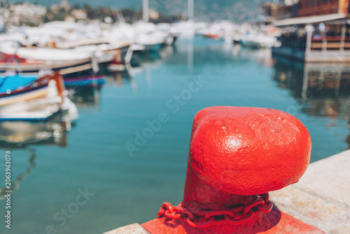 Photography Bright red mooring post stands proudly at a serene harbor, reflecting sunlight o
