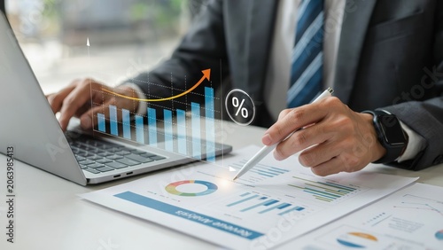 Businessman analyzing financial growth charts and data on a laptop in the office