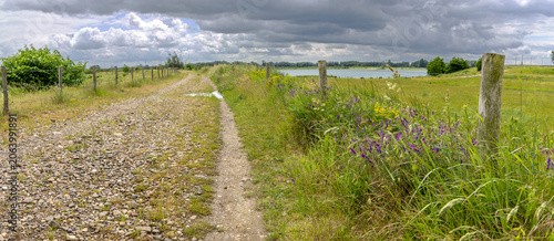 Rural road in Negenoord protected area along the Meuse river near Dilsen-Stokkem, Belgium, designed for water storage and nature restoration