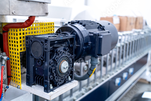 Tableau sur toile Industrial motor and gear reducer powering a conveyor belt in manufacturing faci