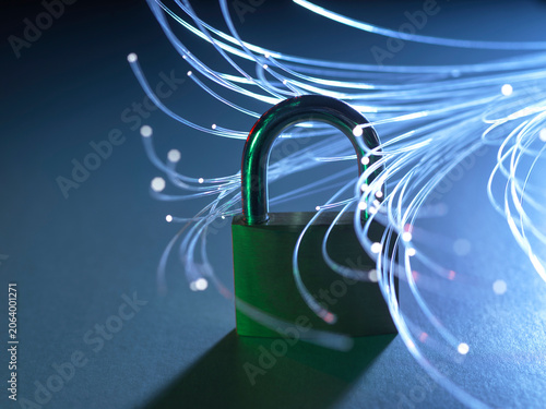 Padlock with glowing fiber optic strands representing data security and internet.