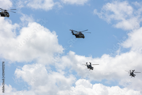 Fotografija Military transport helicopter flies cloudy sky accompanied attack helicopters formation