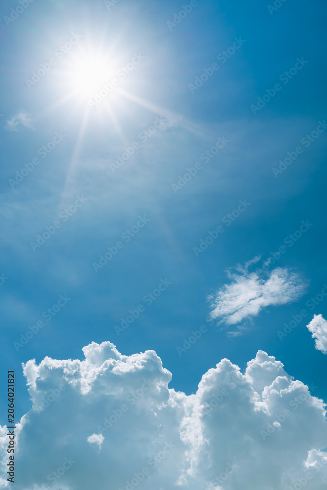 Obraz premium Summer blue sky background, Beautiful sunbeam and bright sunray flare over white clouds.