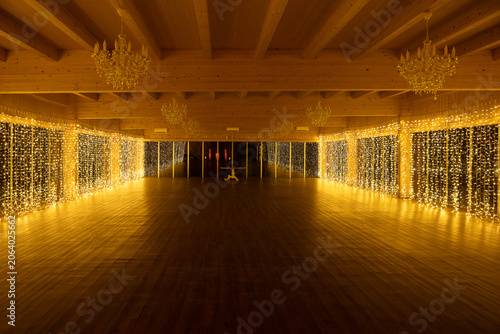 Empty ballroom decorated with string lights for event