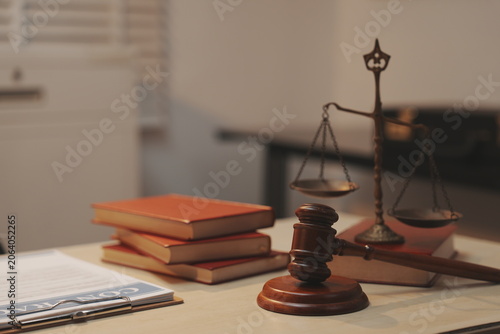 Foto A dramatic, selective-focus close-up shot of a wooden judge's gavel being struck down onto its sound block