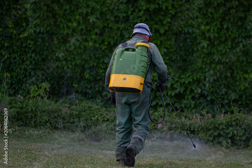 Pest Control Worker Spraying Residential Yard for Tick and Insect Prevention