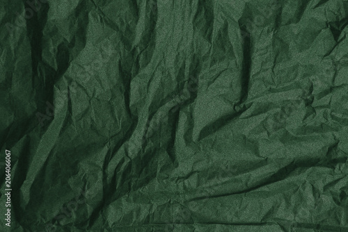 Deep emerald green crumpled paper texture, organic wrinkled forest foliage color background for eco friendly branding