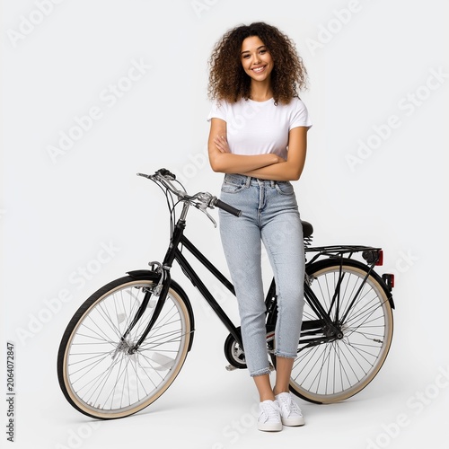 Young woman standing beside a modern bicycle and smiling.
