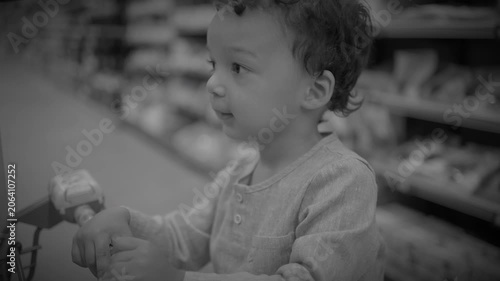 Close-up of young child with curly hair in softly lit supermarket aisle