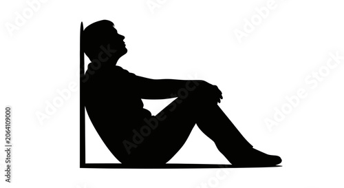 Obraz na plátně Silhouette of a man leaning against a wall, looking up thoughtfully