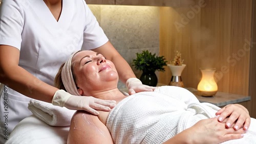 Beautician performing shoulder massage for woman in spa salon. Relaxing wellness procedure for client. Anti stress therapy in professional studio, body care concept.