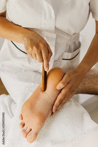 Close up of special foot massage therapy session. Female massage therapist's hands.
