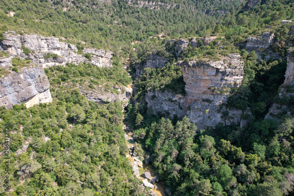 Fototapeta premium Aerial view of La Febró Gorge and La Gorguina waterfall and natural pools on sunny summer day. Tarragona, Spain.