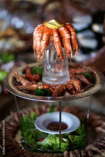 Festive shrimp arrangement with dipping sauce on a tiered stand prepared for a buffet or banquet.