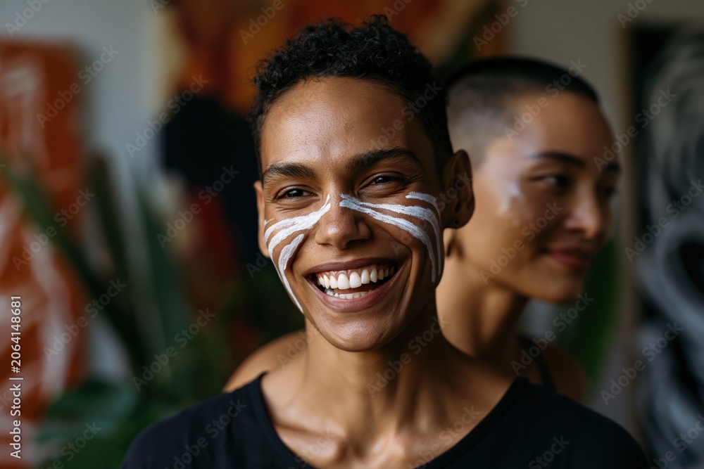 Fototapeta premium Smiling woman with white facial paint markings for portrait background and inclusive wellness campaign design