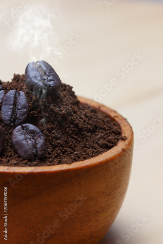 Coffee beans roasted dark and mashed on a with a brown background.