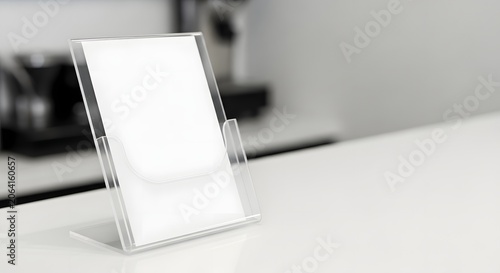 Empty transparent acrylic stand with blank paper on a white table, ready for your message or advertisement.