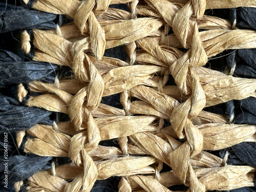 Fotografie Close up of woven natural raffia and dark fibers creating a textured pattern fee