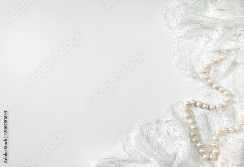 White lace fabric and pearl necklace elegant background