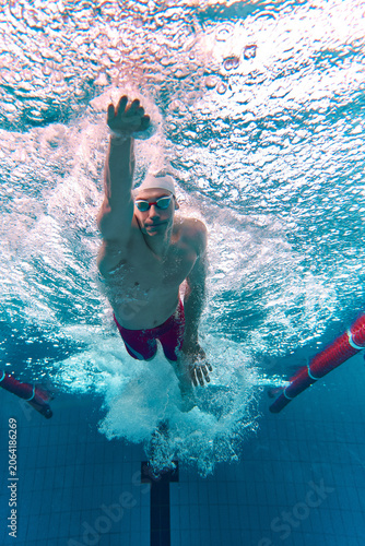 Fotografía Male swimmer pushing through water in pool lane