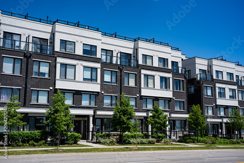 Konstfotografi View of modern townhouse residential buildings under blue sky.