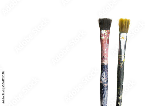 Close-up of dirty art brushes with black and yellow bristles on white background