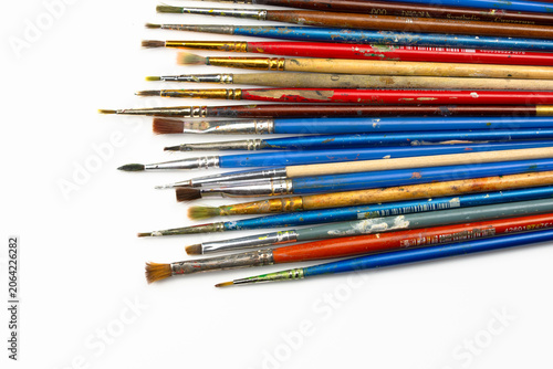 Set of dirty art brushes lying in diagonal composition