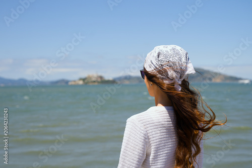 Bild auf Leinwand Young woman gazing across San Francisco Bay toward Alcatraz Island