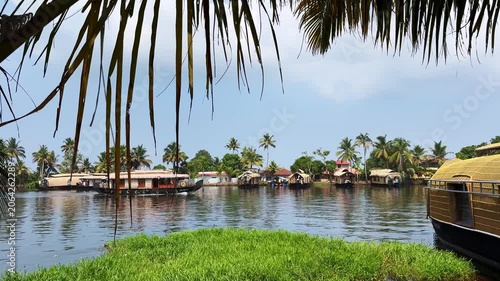 Traditional houseboats moving along the tranquil backwaters of Kerala, surrounded by lush tropical scenery, showcasing the region’s unique waterways and tourism culture