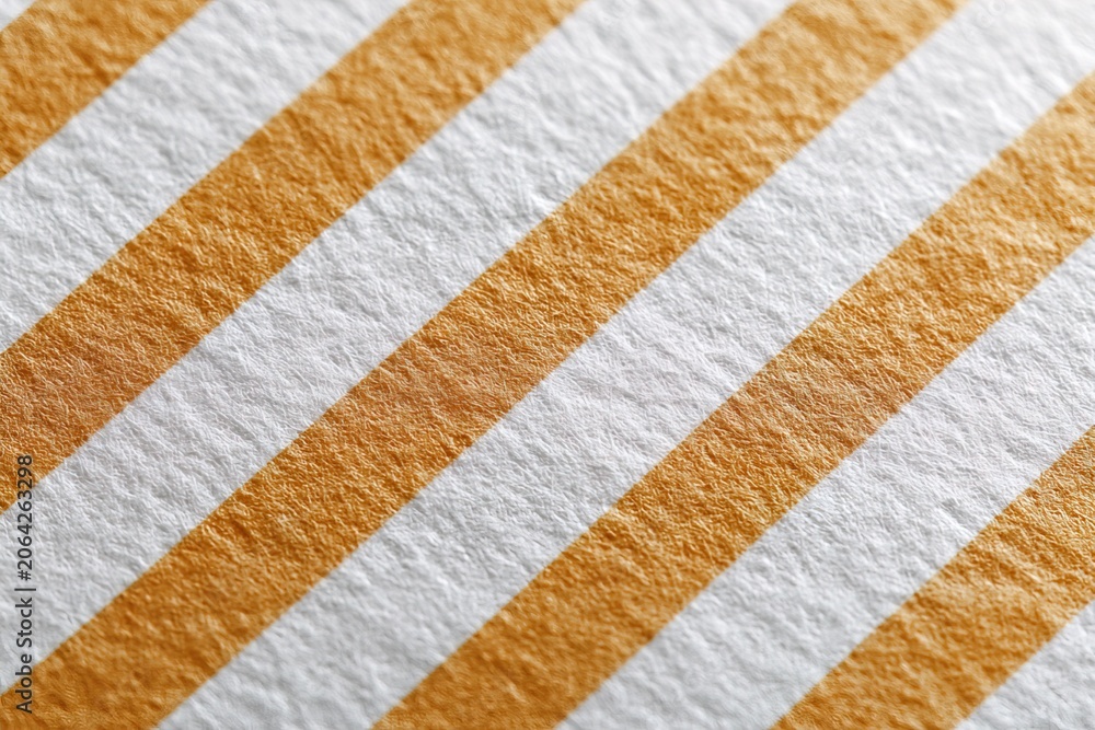 Fototapeta premium This scrapbook sheet features a design of orange and white stripes, perfect for creative projects. The texture and layout reflect styles from earlier decades, making it a great choice for crafts