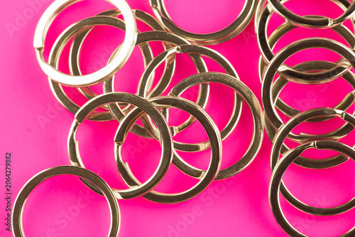 multitude of key rings laid out on a pink background