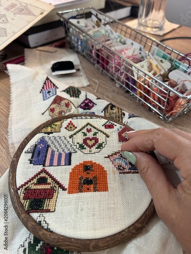 Obraz na płótnie Hand Embroidering Colorful Birdhouses with Cross Stitch at Craft Workspace