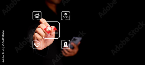 Konstfotografi Hand interacting with a holographic touchscreen showing floating app icons (home, SOS, alert) while holding a smartphone, implying mobile control and digital security