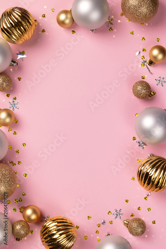 Christmas ornament frame with gold and silver decor on pink background. Flat lay of festive holiday decoration for New Year celebration. Top view, copy space