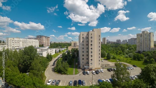 High angle view of city residential buildings under moving clouds in daytime timelapse