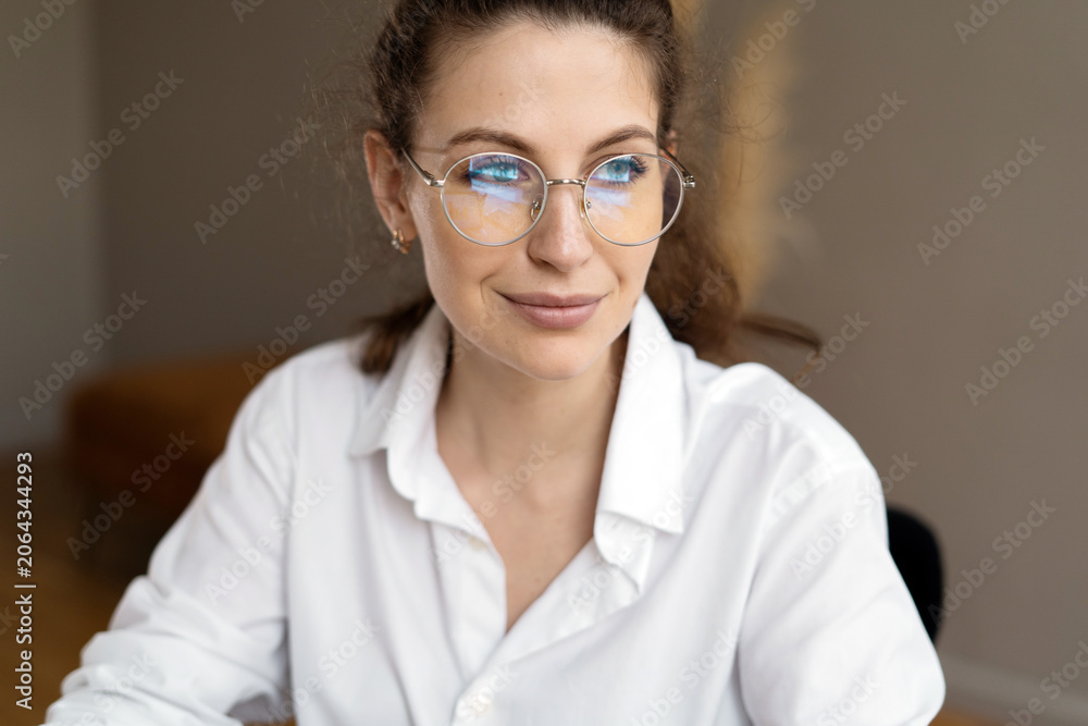 Fototapeta premium Creative professional in a stylish white shirt working intently in a modern office space illuminated by natural light