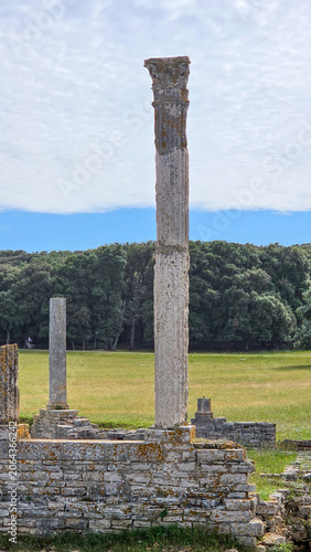 Ancient Ruined Stone Columns in Open Green Field