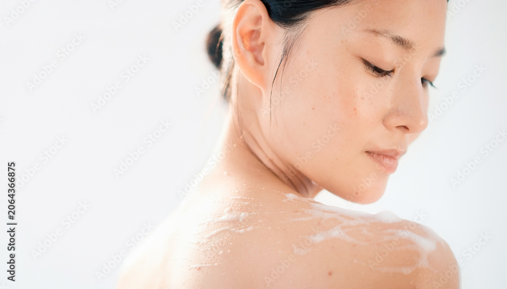 Naklejka premium Beautiful Asian woman with clean skin looking down 美しい肌の女性の横顔