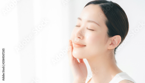 Peaceful Asian woman closing eyes with gentle smile 目を閉じて優しく微笑む穏やかなアジア人女性