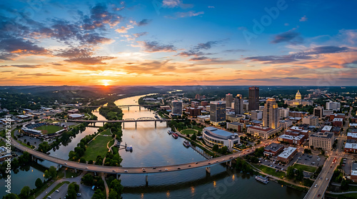 Aerial View of a Modern City Skyline at Sunset with a River Flowing Through the Urban Landscape