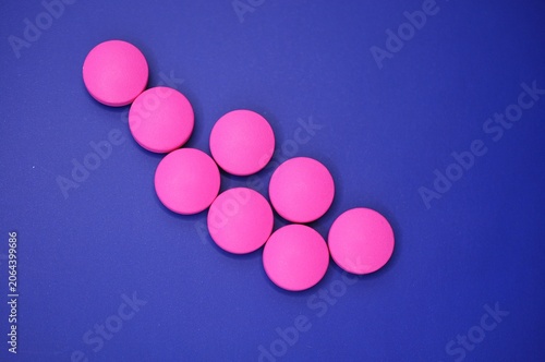 medication - pink pills on blue background 