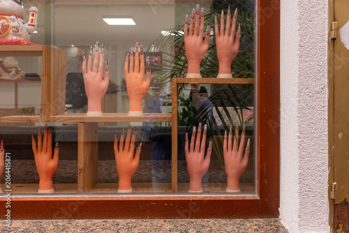 Billede på lærred Artificial display hands featuring elaborate acrylic nail designs showcased in a beauty salon window
