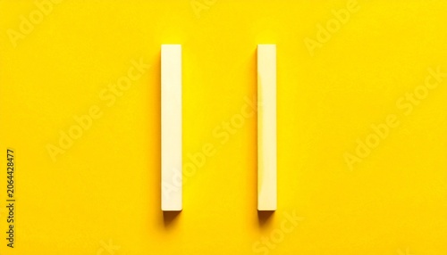 Two White Chalk Sticks on Yellow Background