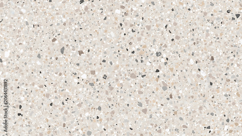This image depicts a beige-toned terrazzo surface featuring scattered fragments of dark gray, brown, and white stone
