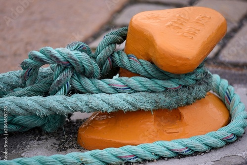 Φωτογραφία Ultra-high-molecular-weight polyethylene mooring rope tied around an orange bollard on Akershusstrandaat at the Oslo Havn in Norway