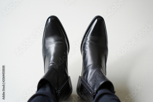 Close up of black leather cowboy boots with pointed toe and zipper