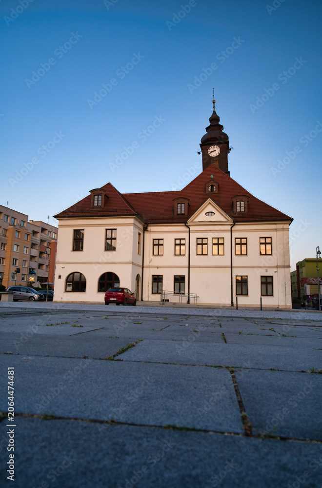 Obraz premium Historic Town Hall With Clock Tower Over Quiet Urban Square At Sunset - City Of Lubin.