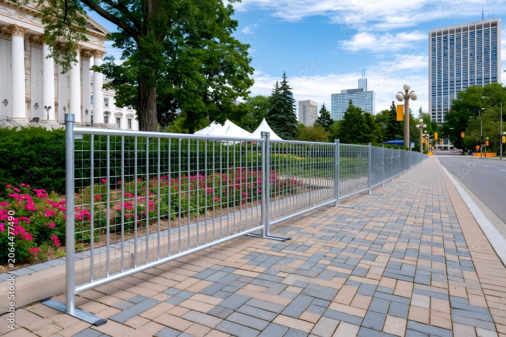 Naklejka premium Metal fence barriers along Toronto city sidewalk