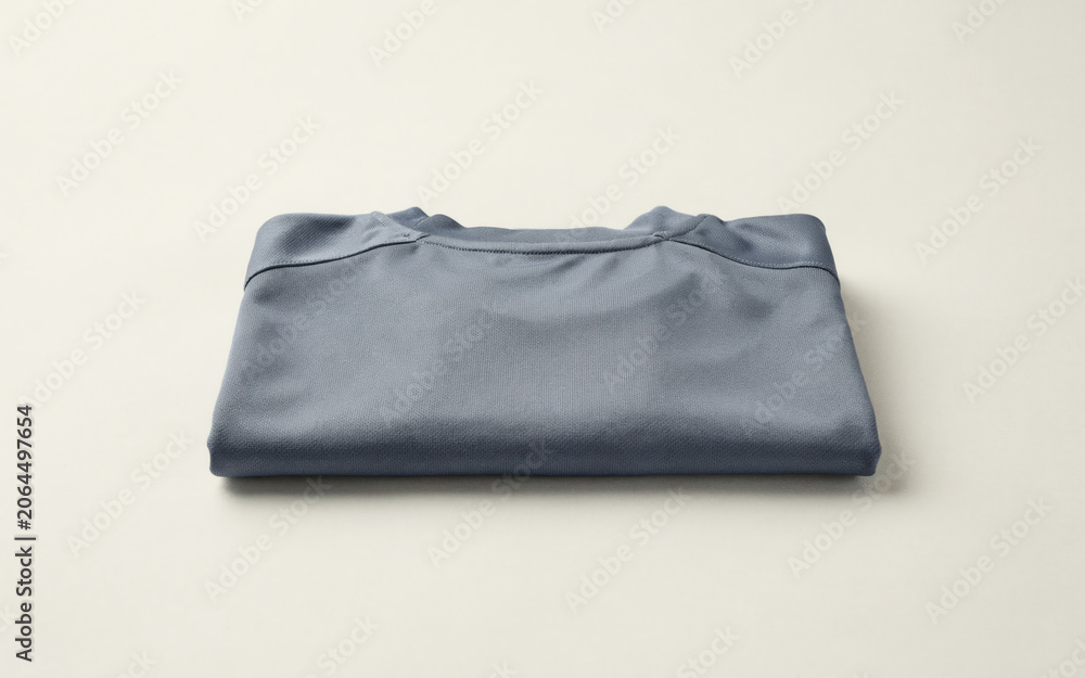 Fototapeta premium Folded blue denim jacket with a slightly worn and distressed look, displayed on a white background, distressed