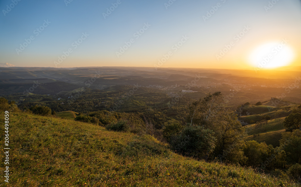 Fototapeta premium View of the mountains and Kislovodsk from the observation decks of the Kislovodsk Park. Evening sunset over the mountains of Kislovodsk.